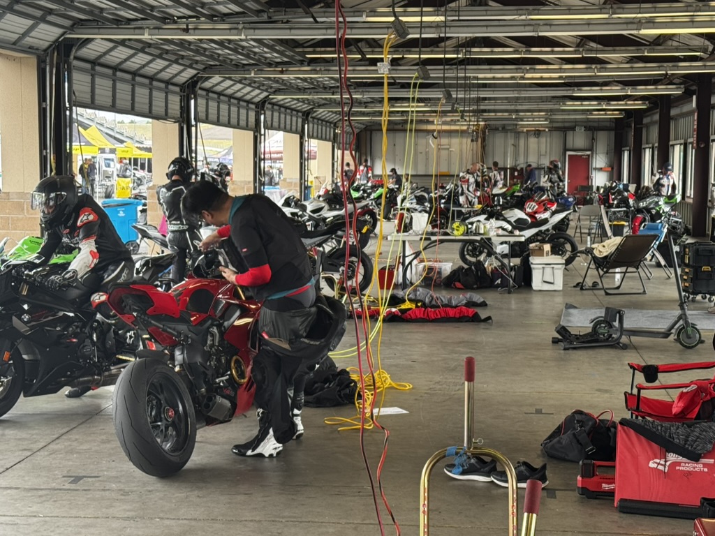 Riders and motorcycles preparing for a track day.